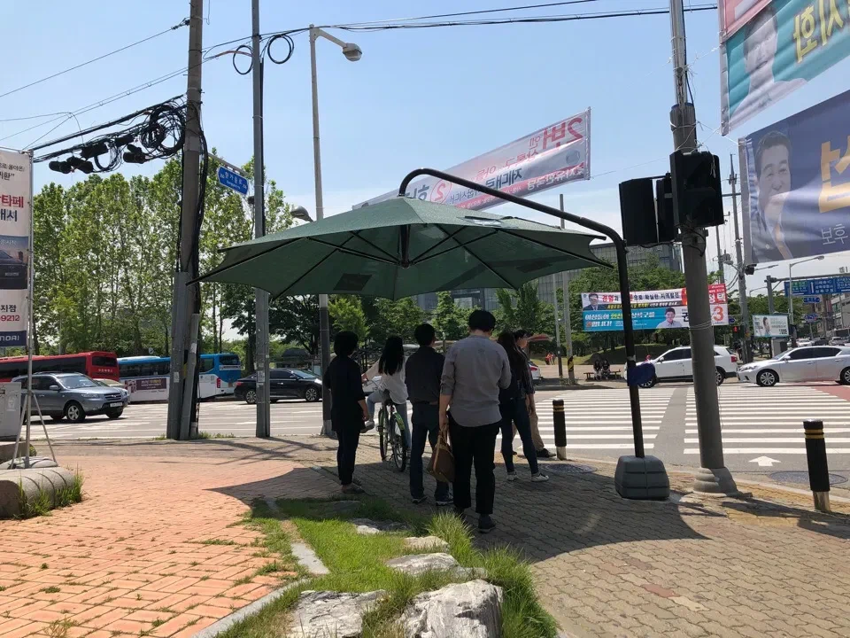 Большой уличный зонт рядом с пешеходным переходом
