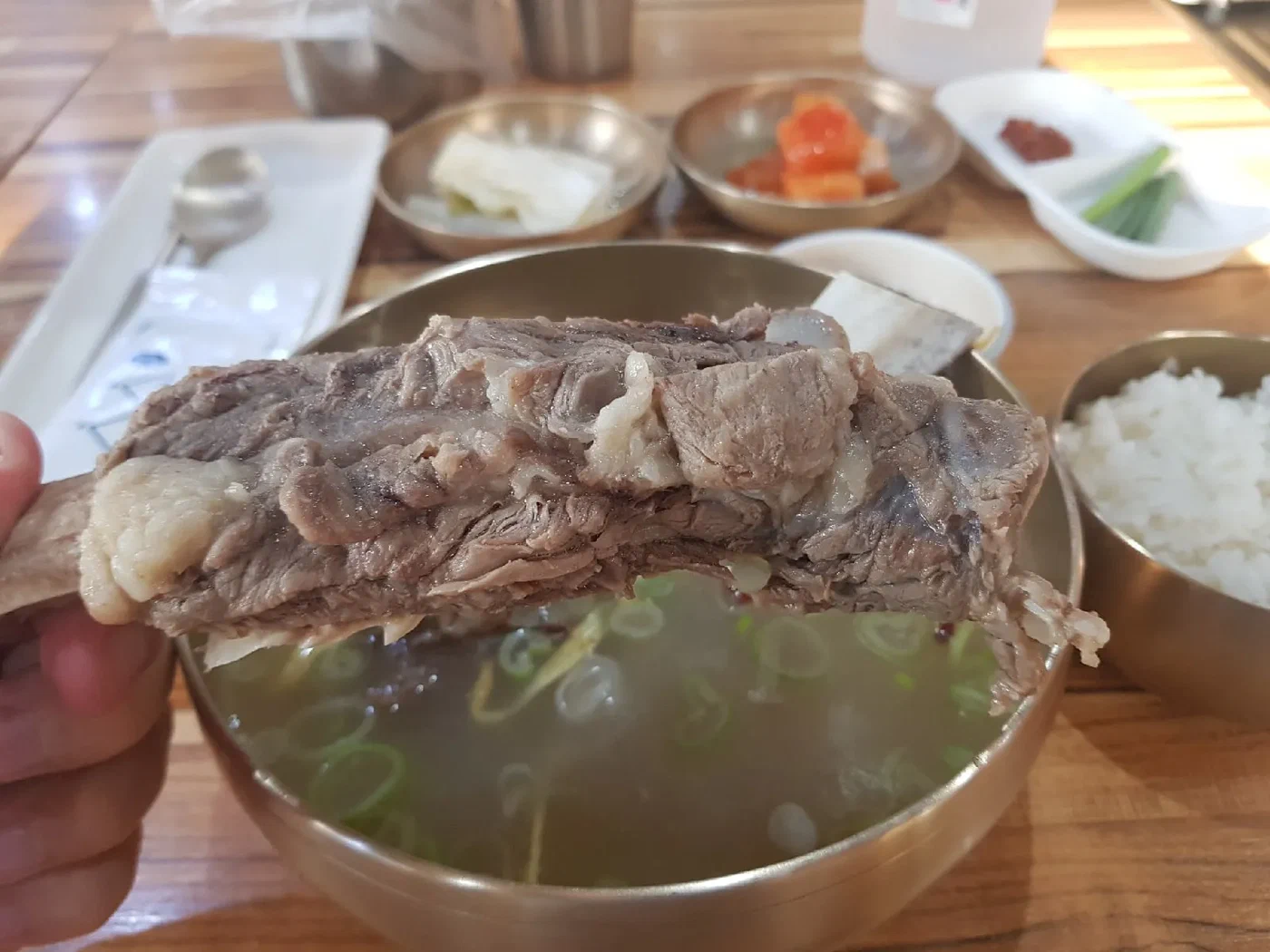 Кусок мяса над тарелкой супа